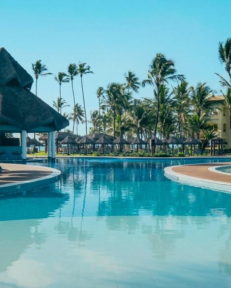 Espreguiçadeiras à beira da piscina, de frente para o mar
